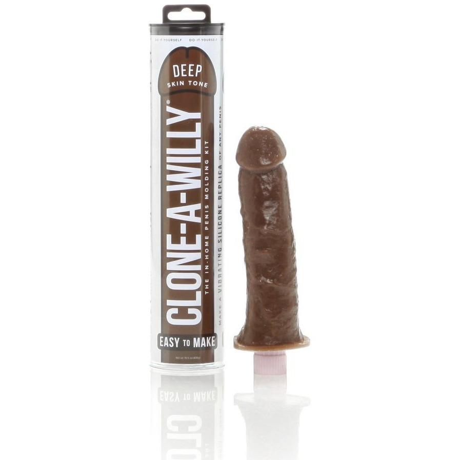 The Clone-A-Willy Kit - Vibrating by Empire Labs in deep skin tone comes in a cylindrical package and includes a sample phallic cast on a stand. Made with body-safe silicone, its perfect for creating custom penis replica molds.