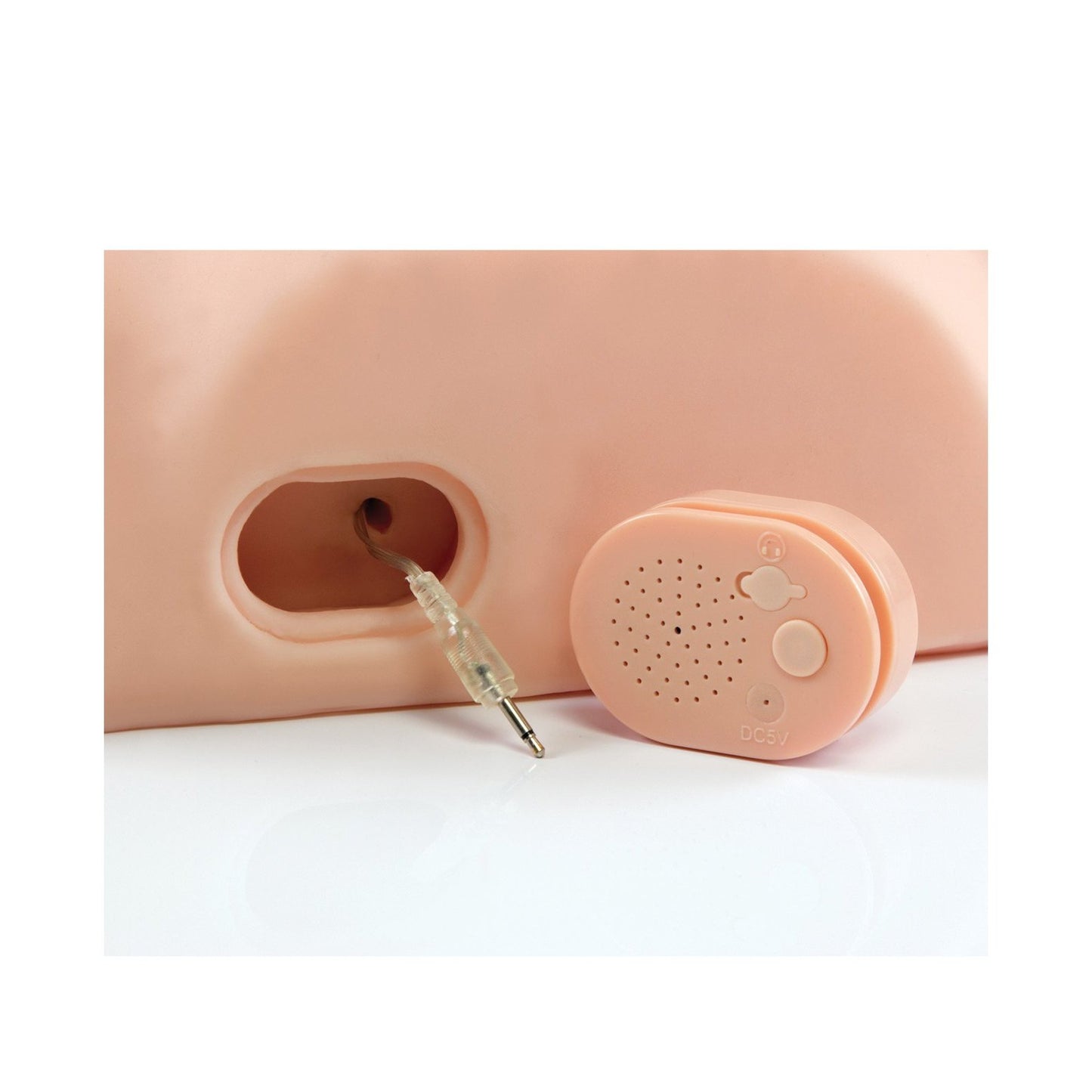 A close-up of the USB rechargeable Dirty Talk PDX Fuck Him Silly Masturbator shows its speaker and 3.5mm audio jack on a peach-colored surface, featuring buttons and motion-activated dirty talk for an immersive experience.