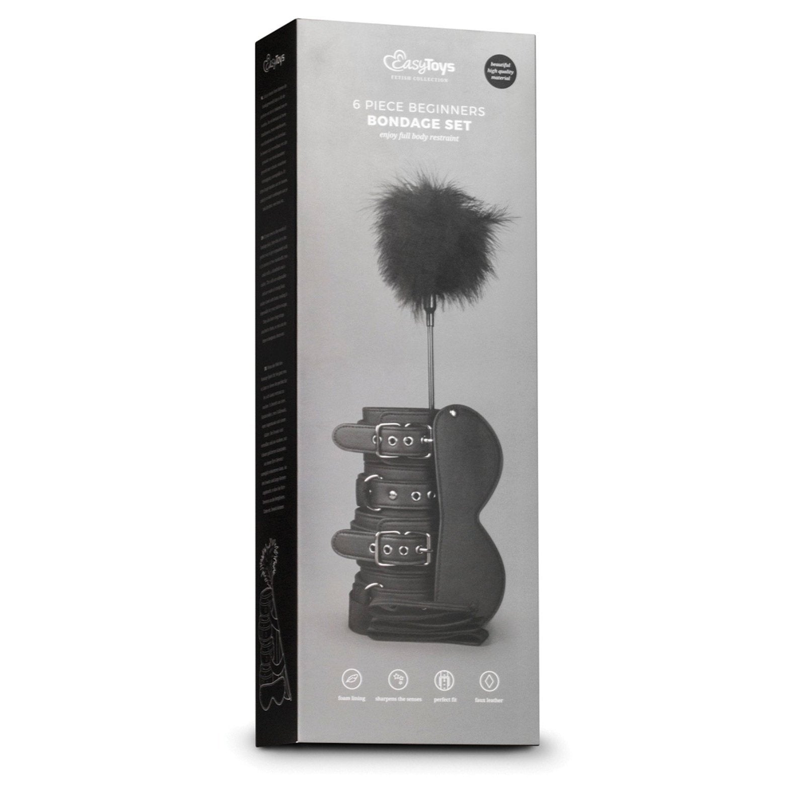 A box labeled Easy Toys Beginners 6 Piece Kit features images of black bondage items like cuff restraints and a feather tickler against a gray background, underscoring its beginner-friendly appeal.