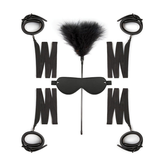 The Easy Toys Beginners 6 Piece set, featuring black cuff restraints, a feather tickler, an eyemask, and adjustable straps, is symmetrically arranged against a white background.