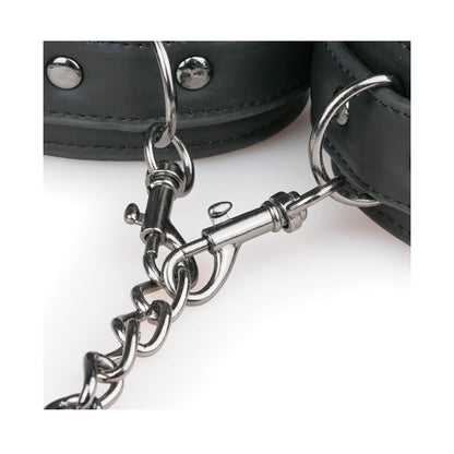 Close-up of the Easy Toys Faux Leather Collar w/ Handcuffs featuring black faux leather and metal studs, connected by a metal chain and clasp. These bondage restraints appear sturdy and secure against a plain white background.