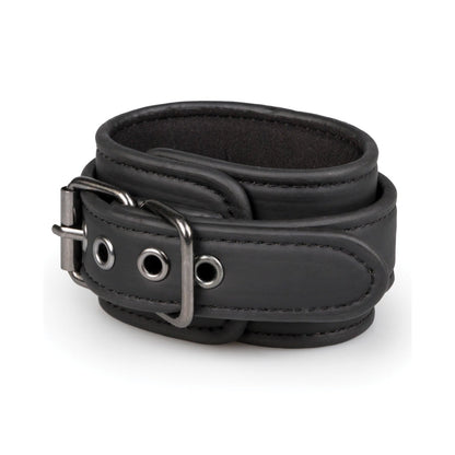 The Easy Toys Hogtie with Hand & Ankle Cuffs features a black faux leather wrist cuff with metal buckle and eyelets, visible stitching, and a smooth texture. The double strap design allows for adjustable sizing, making it a sleek addition to any bondage gear collection.