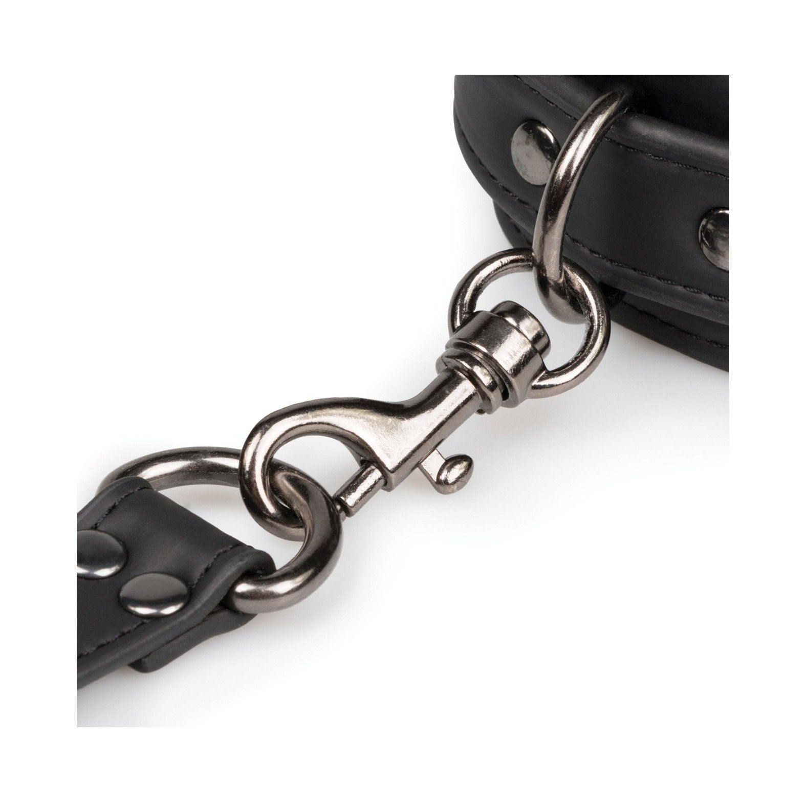 A close-up of a metal clasp connects two black leather straps with rivets, typical of durable fasteners in bondage gear. These straps could be part of the Easy Toys Hogtie with Hand & Ankle Cuffs by Easy Toys, featuring an adjustable cuff set.