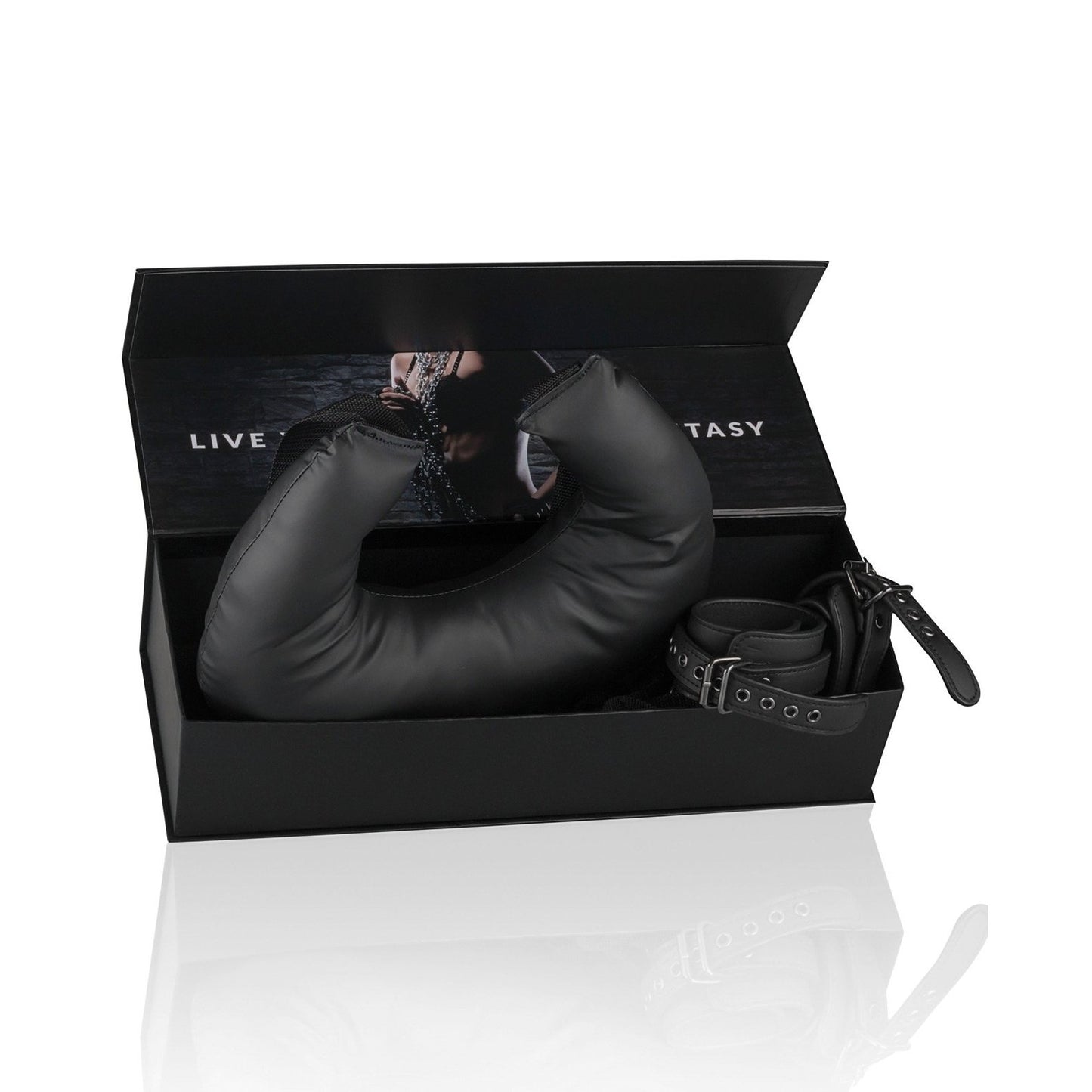 A black Easy Toys bondage kit by Adams Toy Box, with fully adjustable restraints and a padded faux leather item, comes in an open box. The lid shows part of a photo of someone in a chain collar and reads: LIVE YOUR FANTASY.