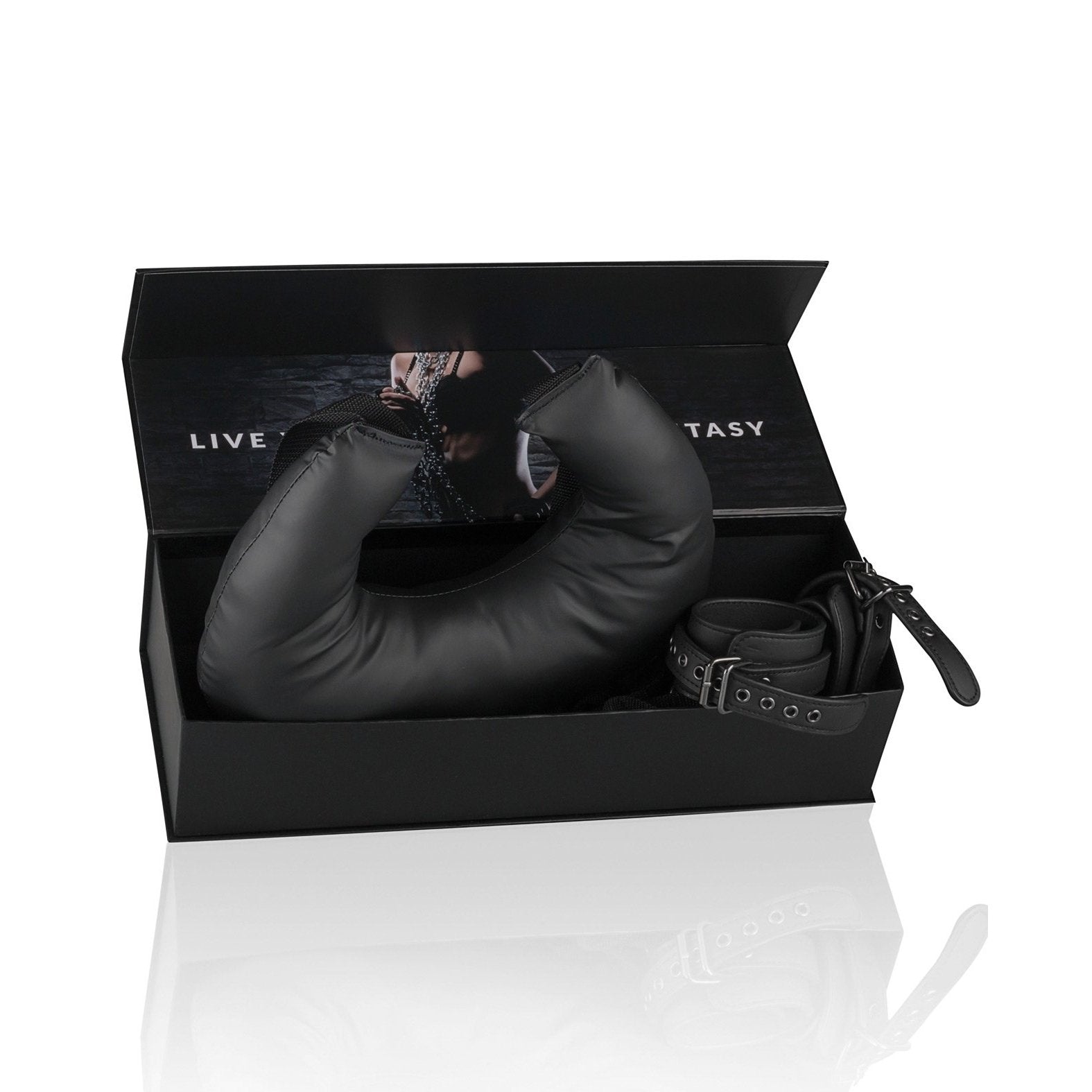 A black Easy Toys bondage kit by Adams Toy Box, with fully adjustable restraints and a padded faux leather item, comes in an open box. The lid shows part of a photo of someone in a chain collar and reads: LIVE YOUR FANTASY.