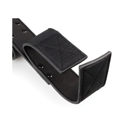 The Easy Toys Wrist & Ankle Bondage Bar features a close-up on a black leather strap with metal rivets, Velcro for adjustable fastening, and a padded end for comfort. Its BDSM-inspired design promises durability, reminiscent of faux leather cuffs.