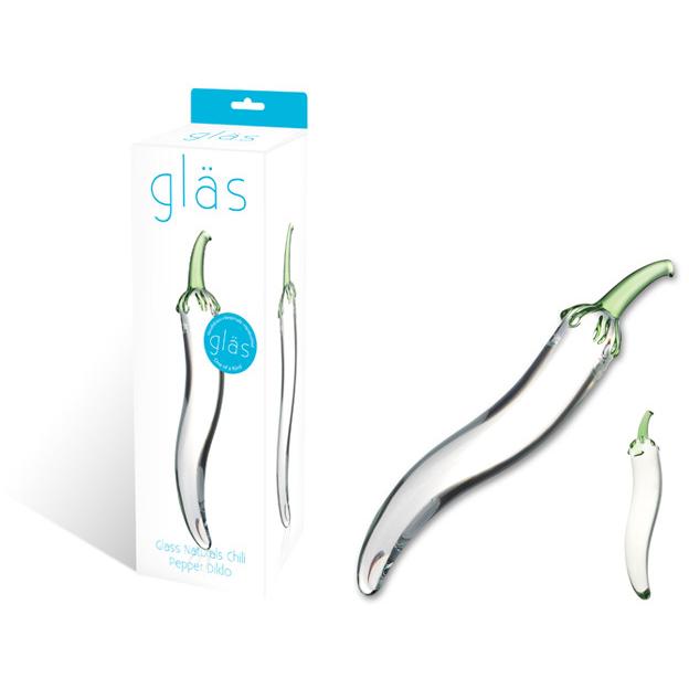 The Gläs Glass Naturals Chili Pepper Dildo, made of fracture-resistant glass, sits beside its packaging featuring the brand name Gläs and an image of the product. Its transparent, curved, and adorned with green accents resembling a chili stem.