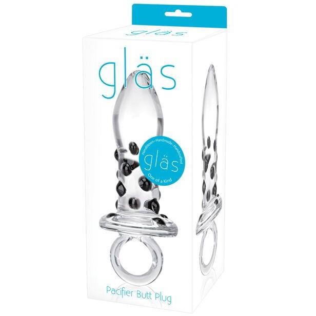 The Adams Toy Box Glas Pacifier Glass Butt Plug is elegantly packaged, highlighting its clear glass design with black accents and a ring handle. Made from body-safe, temperature-resistant glass, it ensures style and safety. The box features turquoise and black text on a white background.
