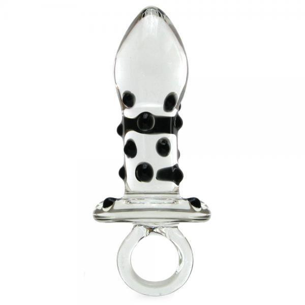 The Glas Pacifier Glass Butt Plug from Adams Toy Box is a transparent figurine with a tapered, bulbous top and a pattern of black dots. Its temperature-resistant base features a loop-like circular handle for easy grip, all showcased elegantly against a plain white background.