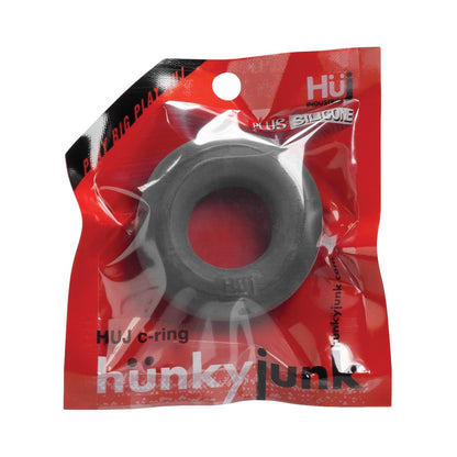 The image shows a red-clear package with a black cock ring labeled Hunky Junk C Ring - Singles by Hunky Junk, highlighting the PLUS SILICONE blend on top.