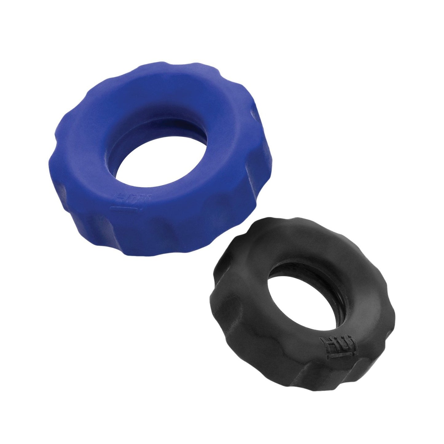 The Hunky Junk Cog Ring 2 Size Double Pack features two hollow rubber toys on a white background: one larger blue and the other smaller black. Both have a textured, grooved surface crafted from a durable TPR/silicone blend.