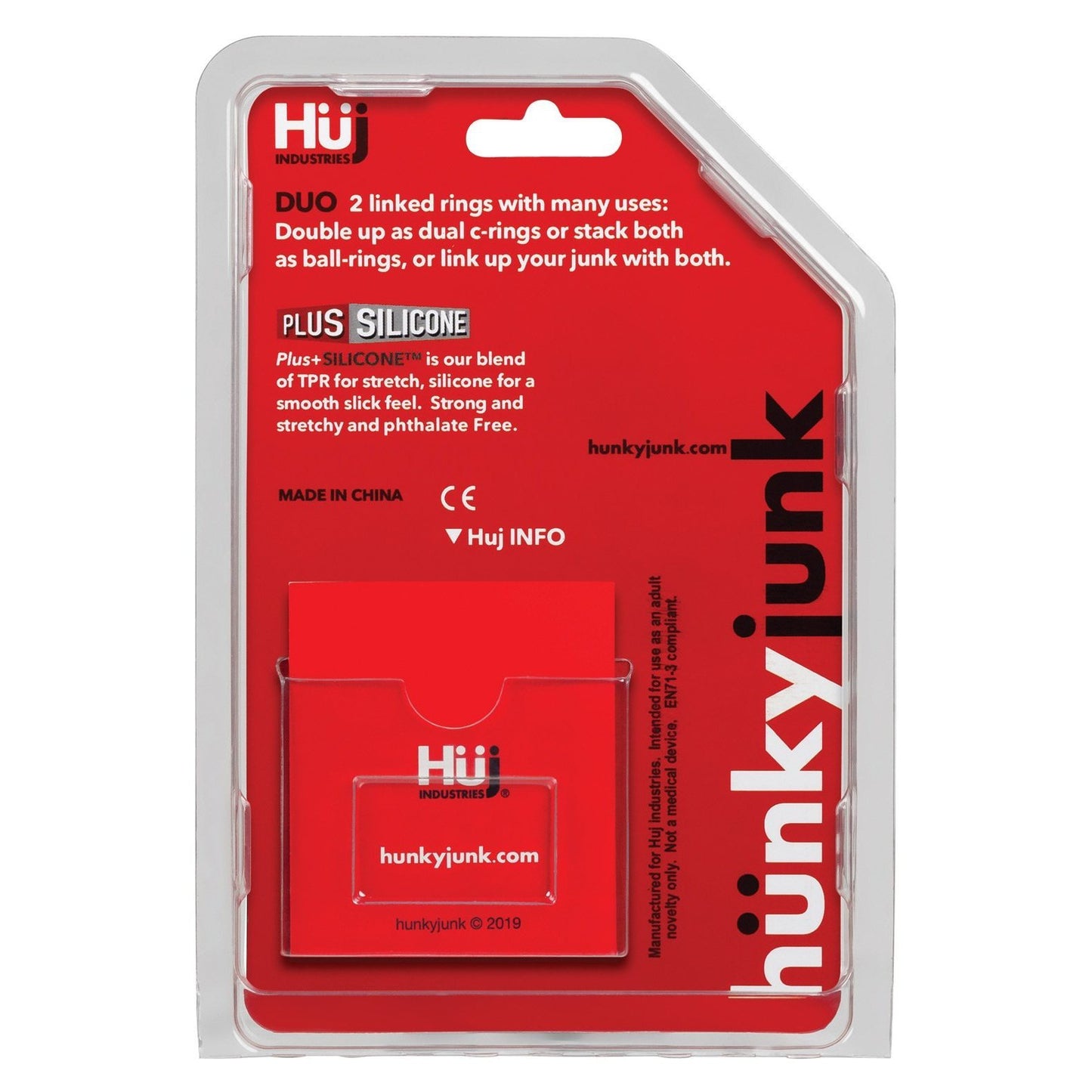 The image features the back packaging of Adams Toy Boxs Hunky Junk Duo Linked Cock & Ball Rings, showcasing the innovative C-ring design. Product information and branding are elegantly displayed in white and red text on a clear plastic background, highlighting the TPR/silicone blend.