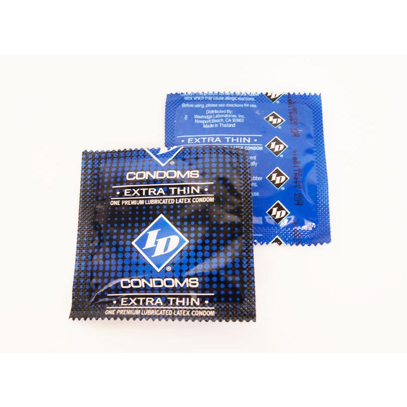 Two packets of ID Extra Thin Condoms - Box of 3, one black and one blue, are shown. The black packet in front reads one premium lubed condom, while the blue packet peeks from behind, highlighting their extra thin design for enhanced pleasure.