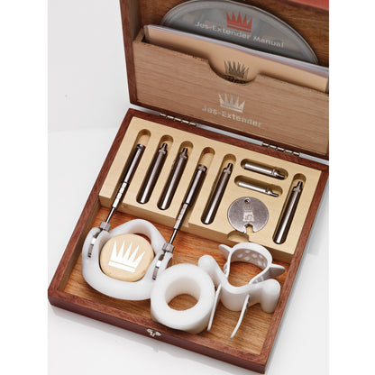 The Jes Extender Original Standard Penis Enlarger Kit by Jes comes in a wooden box with metallic rods, plastic parts, and a circular disc. A manual is on top, while compartments keep everything organized.