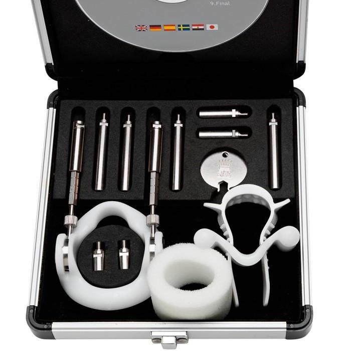 The Jes Extender Titanium Penis Enlarger Kit by Jes is an open metal case with metallic and plastic tools in foam compartments, including rods, rings, clamps, a round metal disk, and a CD. This non-surgical method resembles other penis enlargement tools.