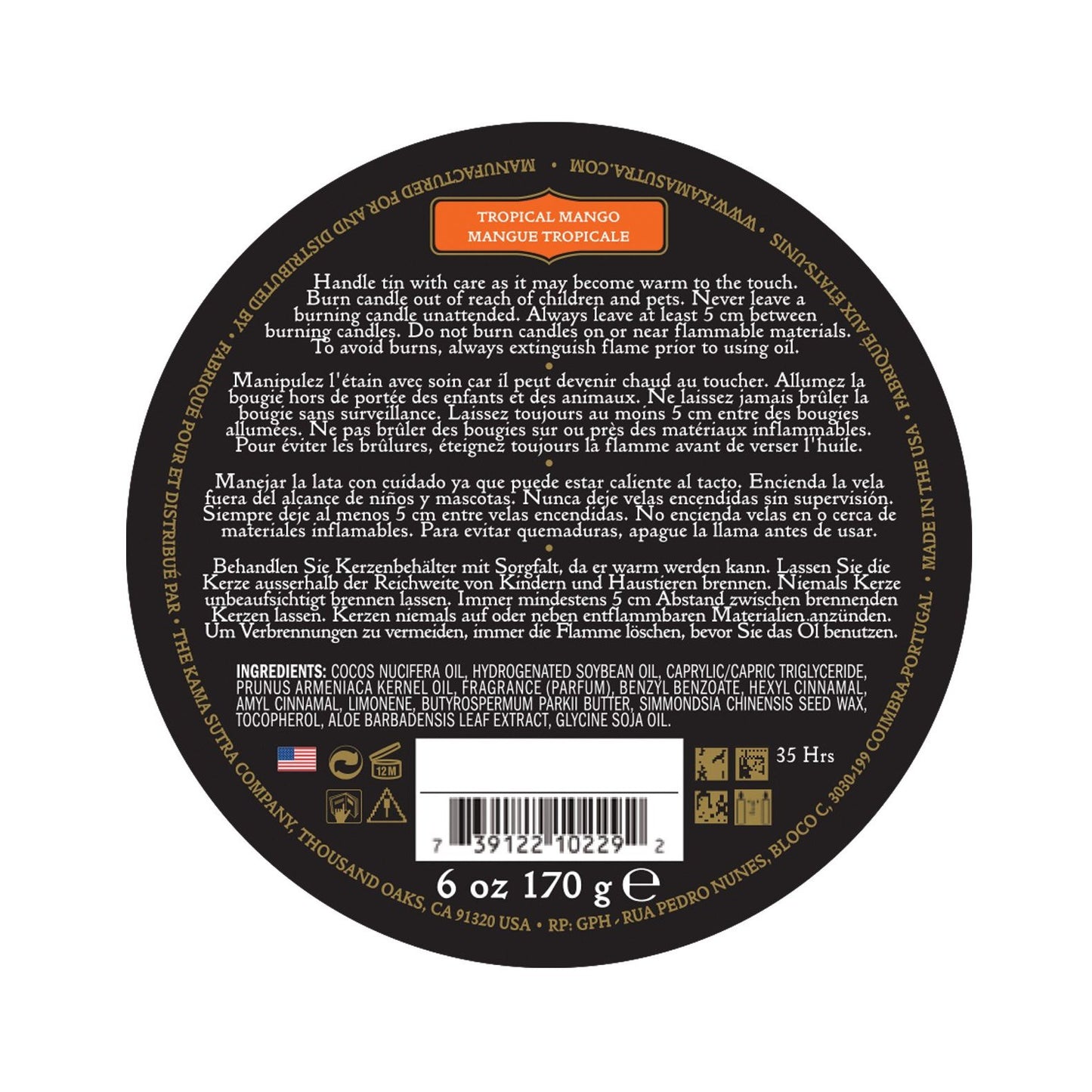 A black circular lid on the Kama Sutra Ignite Massage Candle in Coconut Pineapple shows multilingual safety info, product details, weight (6 oz/170g), 35-hour burn time, and moisturizing formula. It also displays a barcode, manufacturer details, and scent of tropical mango.