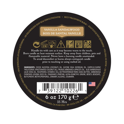 A round label for the Kama Sutra Ignite Massage Candle in Coconut Pineapple includes safety instructions, ingredients, a barcode, and details like 6 oz, 170 g, and 35 hrs. The black label with gold and white text emphasizes its moisturizing formula for a luxurious experience.