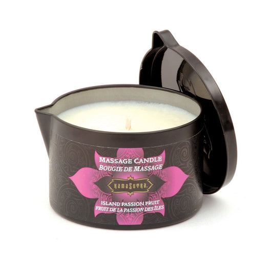 The Kama Sutra Ignite Massage Candle in a dark container with a decorative design, labeled Coconut Pineapple, has a partially open lid revealing its moisturizing formula. The label is in English and French, suggesting it’s ideal for a sensual massage experience.