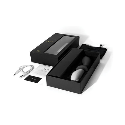 The LELO Loki - Prostate Vibrator comes in a sleek black and grey box set, including two oval-shaped P-spot stimulators, a USB cable, storage pouch, user manual, and warranty card, all adorned with the LELO brand name.