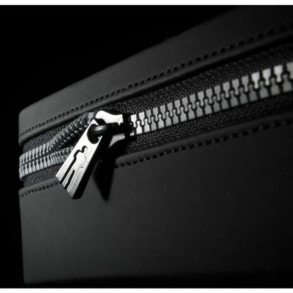 Close-up of a partially open zipper on a black bag, with metal teeth catching the light. This highlights the texture and mechanical detail, akin to the precision and craftsmanship in the Male Edge Extra Penis Enlarger Kit by Male Edge.