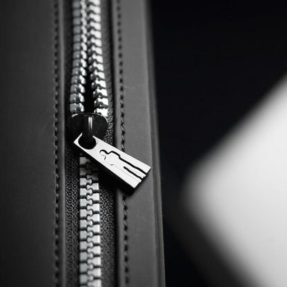 In a detailed close-up, the black zipper with its metal pull tag resembles the precision of a Male Edge Extra Penis Enlarger Kit. Partially open, the zippers teeth contrast with the dark fabric background, as lighting casts subtle shadows to enhance its texture.