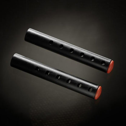 Two black cylindrical objects, similar to the Male Edge Pro Penis Enlarger Kit by Male Edge, featuring holes along their lengths and red caps at one end, set against a dark background.