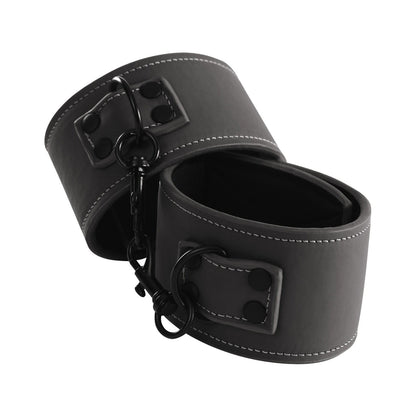 Indulge in rebellion with NS Novelties Renegade Bondage Wrist Cuffs. Made from cruelty-free black faux leather with white stitching and metal rings, they’re ideal for soft fetish sessions. Linked by a detachable chain, these cuffs offer elegant restraint.