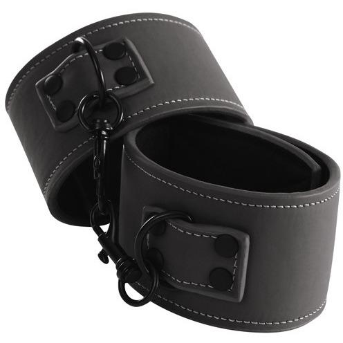 Check out NS Novelties Renegade Bondage Wrist Cuffs—made from cruelty-free leather-look material. These cuffs are linked by a black chain, adorned with silver stitching, and equipped with large metal loops and sturdy clasps for gentle restraint during soft fetish sessions.