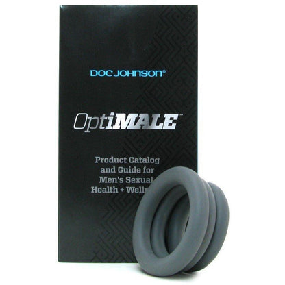 A black product box features OptiMale C Ring Kit Thick and Product Catalog and Guide for Mens Sexual Health + Wellness in white text. In front are two super stretchy silicone rings for long-lasting erections. The top blue text reads Adams Toy Box.