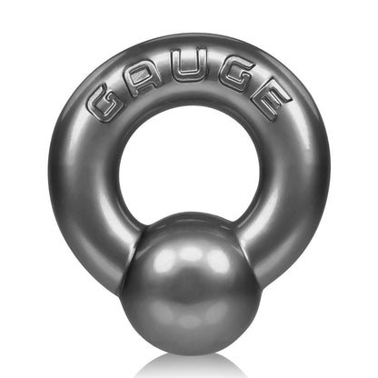 The Oxballs Gauge Cockring by Oxballs is a metallic circular object with GAUGE engraved on top, featuring a spherical element below, similar to a decorative padlock. Crafted with SuperFLEXtpr technology, it can uniquely serve as penis piercing jewelry.