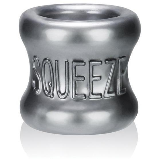 The Oxballs Squeeze Ball Stretcher by Oxballs is a shiny, metallic cylinder with a concave middle, featuring embossed SQUEEZE letters. It is ergonomically designed to reflect light.