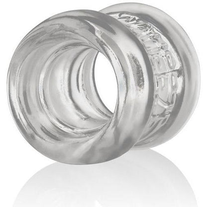 The Oxballs Squeeze Ball Stretcher by Oxballs features a transparent, cylindrical ring with smooth, curved surfaces and a reflective sheen on a white background, embodying an ergonomic design.