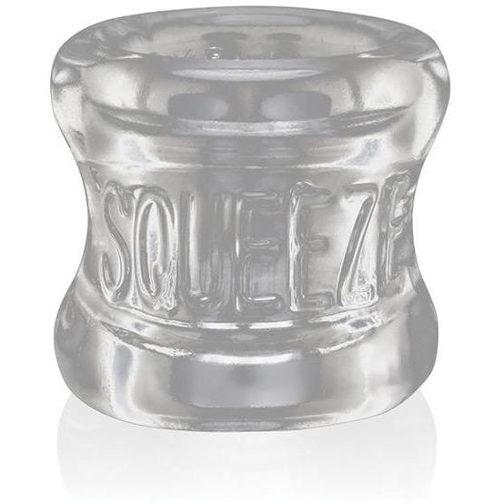 The Oxballs Squeeze Ball Stretcher, by Oxballs, is a clear cylindrical object with SQUEEZE embossed on its glossy surface. Crafted from flexible Flex-TPR material, it offers an ergonomic design for comfort and functionality.