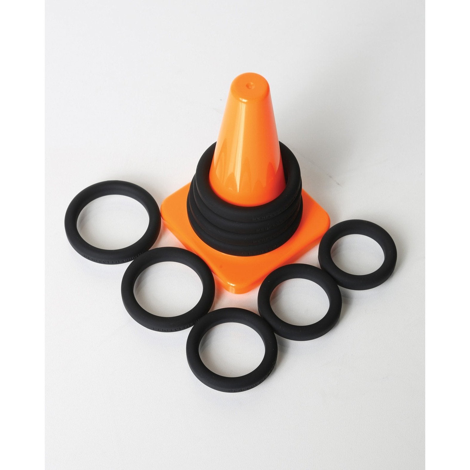 An orange collapsible cone with six Xact-Fit Rings around it on a white background, tailored for the Perfect Fit Play Zone Ring Toss Kit.