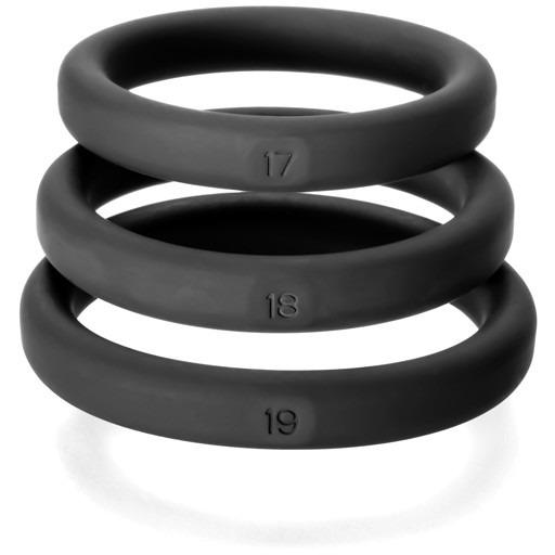 The Perfect Fit Xact Fit 3 Ring Kit includes three black silicone rings in sizes 17, 18, and 19. Designed for enhanced erections, these smooth-finish rings are neatly stacked vertically.