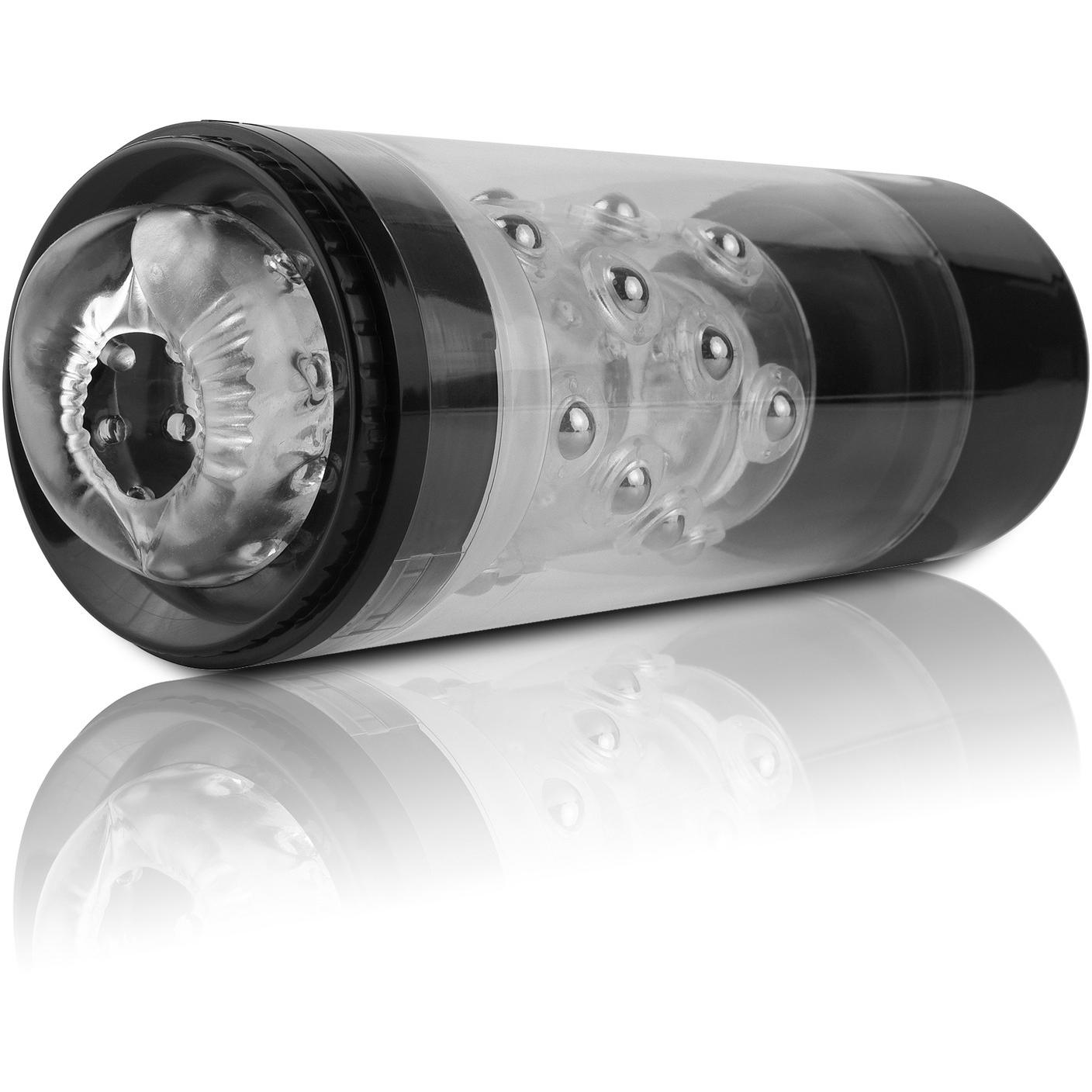 A cylindrical black and transparent object with inner textured ridges, the Pipedream Extreme Roto-Bator by Pipedream, designed for adult use, is displayed on a white reflective surface.