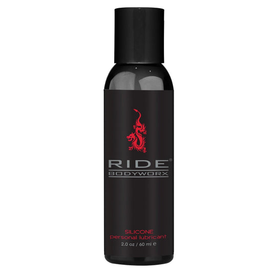 A black 2 oz (60 ml) bottle from Adams Toy Box features Ride BodyWorx in red with a dragon, offering a body-safe and waterproof silicone lubricant for a silky-smooth experience.