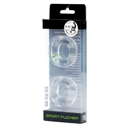 The image shows clear packaging with two transparent, super stretchy c-rings labeled Sport Fucker. The mostly black packaging has white text and a small upper-corner graphic, resembling the sleek Sport Fucker Boner Expansion Kit.