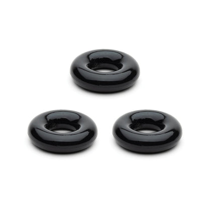 Three sleek, black, round doughnut-shaped objects from the Sport Fucker Chubby Cockring Pack of 3 are evenly spaced on a white background, embodying an enhanced stylish look.