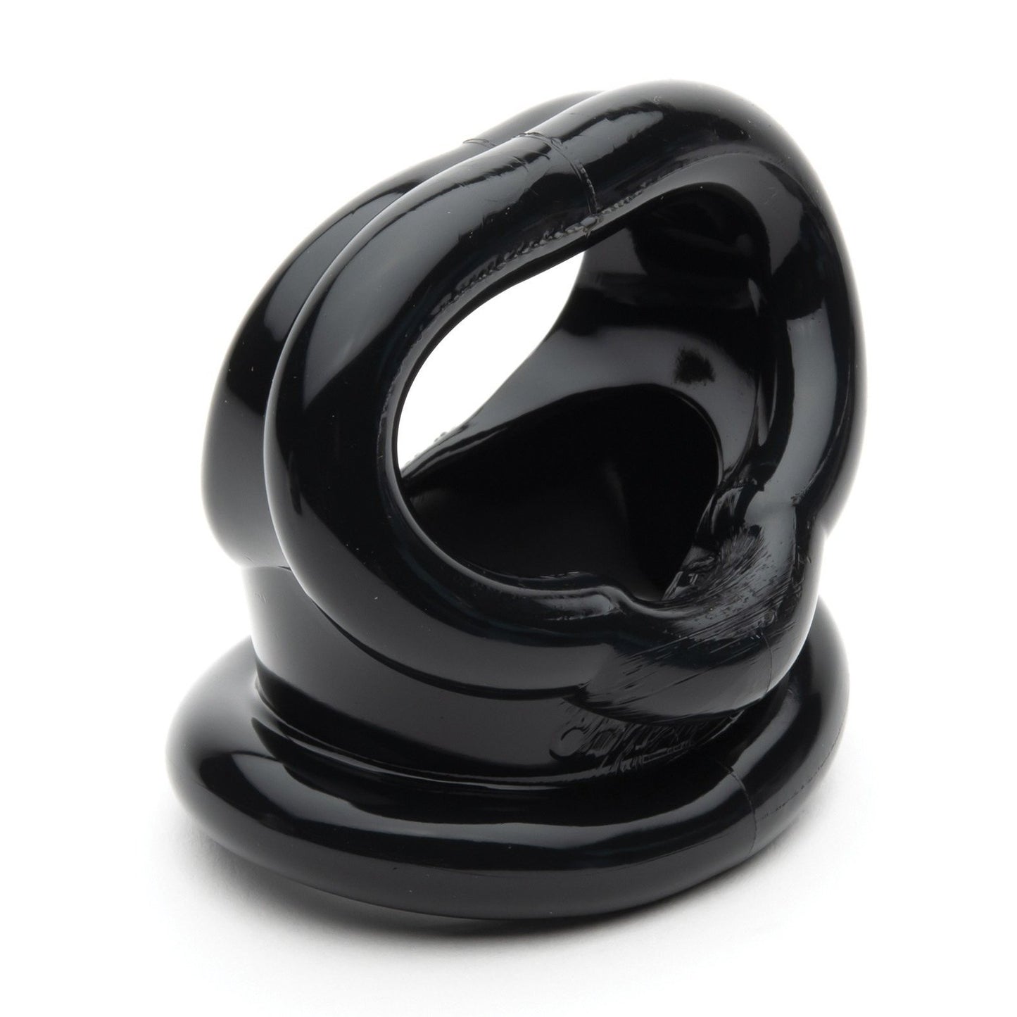 Close-up of the Sport Fucker Cock Harness by Sport Fucker, a glossy black object made of TPR material with interconnected loops and openings, placed on a flat white surface.