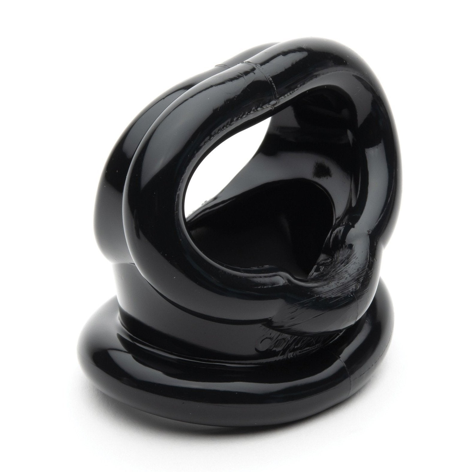 Close-up of the Sport Fucker Cock Harness by Sport Fucker, a glossy black object made of TPR material with interconnected loops and openings, placed on a flat white surface.