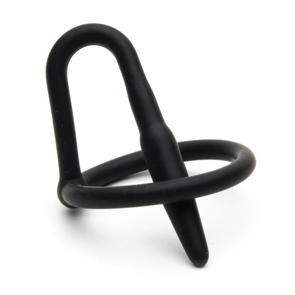 The Sport Fucker Cock Plug by Sport Fucker is a black, flexible object made from medical-grade silicone, with a loop and cylindrical protrusion resembling modern abstract sculpture.