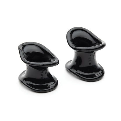 Two black, glossy ergonomic wedges made from a TPR blend, designed to hold doors open. Their sleek, curved form allows for easy placement and removal under a door. Product: Ergonomic Ball Stretcher Kit by Sport Fucker.