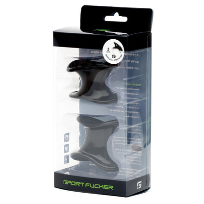 The image displays a transparent box with black rubber rings from the Sport Fucker Ergonomic Ball Stretcher Kit. The packaging features text and graphics, with the brand name Sport Fucker in green lettering at the bottom.