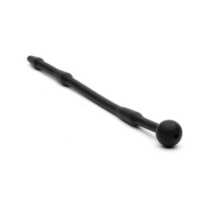 The Sport Fucker Piss Play Sound is a black, medical-grade silicone wand by Sport Fucker, featuring a beaded pattern with a spherical handle on one end and tapering on the other. It is styled elegantly against a white background.