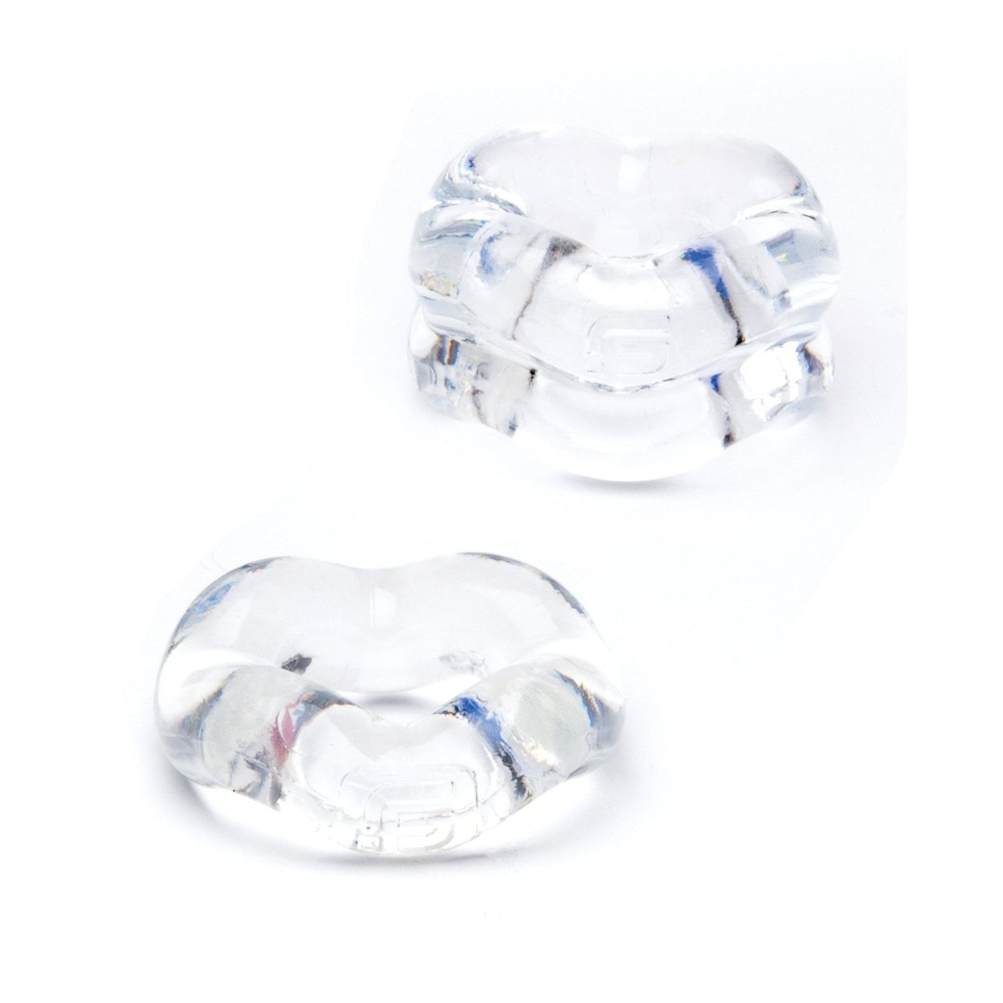 Two transparent, glass-like heart-shaped objects with smooth surfaces rest on a white background. They appear small yet reflective, showcasing their clarity and form—much like the elegant minimalism of the Sport Fucker Revolution Combo Set by Sport Fucker.