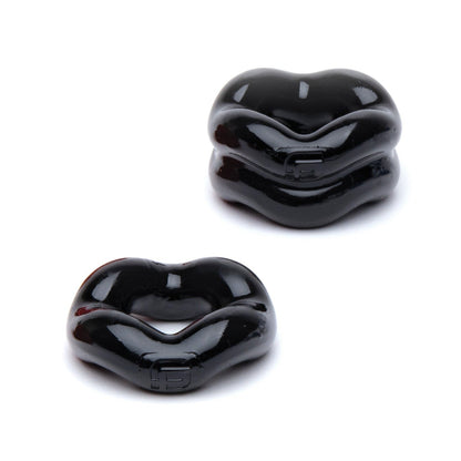 Two glossy black sculptural objects with wavy forms rest on a white background, their shiny surfaces reflecting subtle light akin to the sleek design of the Sport Fucker Revolution Combo Set by Sport Fucker.