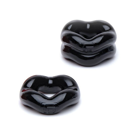 Two glossy black sculptural objects with wavy forms rest on a white background, their shiny surfaces reflecting subtle light akin to the sleek design of the Sport Fucker Revolution Combo Set by Sport Fucker.