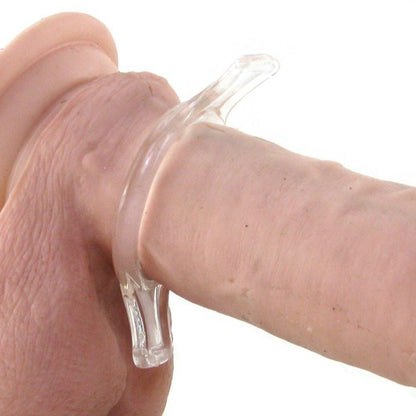 A close-up shows a transparent, flexible ring from the TitanMen Tools Cock Ring Set by TitanMen around a cylindrical item. Made of soft, clear material, this stretchy cock ring is near the rounded end of the flesh-toned object, designed to enhance erection strength.